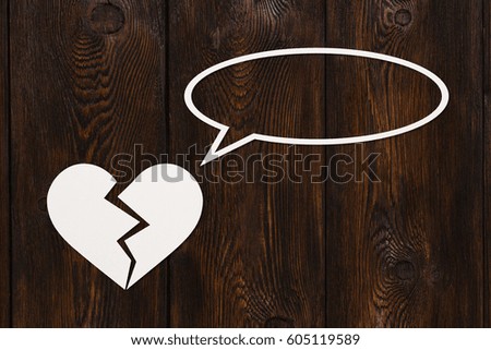 Paper broken heart is talking or thinking on wooden background. Abstract conceptual image with copyspace.