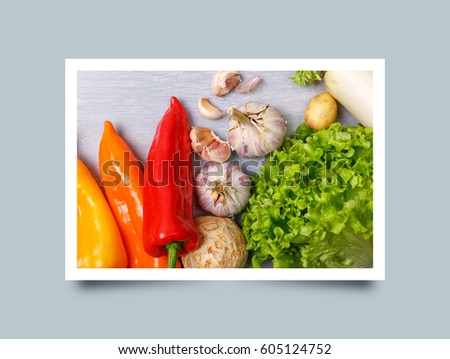 Vegetables. Garlic, lettuce salad and pepper. White radish and celery. Organic food on wooden table. Photo frame design with shadow.