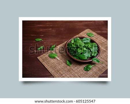 Spinach leaves in bowl. Raw fresh vegetable. Fresh natural plant leaf. Organic bio food on rustic wooden table. Photo frame design with shadow.