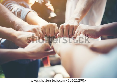 Close up of young people putting their hands together. Team with stack of hands showing unity and teamwork. Royalty-Free Stock Photo #605212907