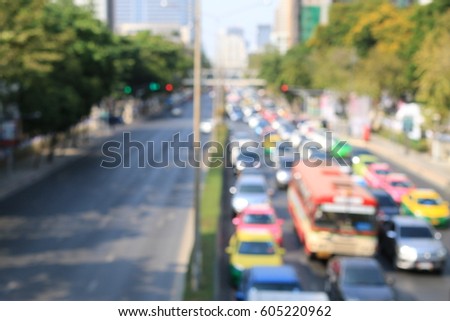 blured image of traffic jam on the road and opposite side of the road is empty with green environment.  busy road in the morning