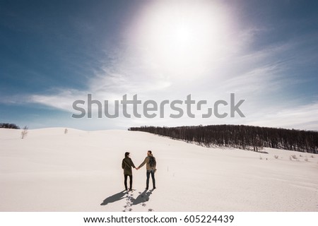 Couple in love walks in winter in the snow. Man and woman traveling. Couple in love in the mountains. Travelers in the mountains. Winter walk. Winter adventures. Winter walk. Loving couple
