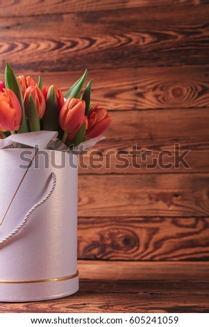 cutout image of a flowers box with orange tulips on wood background