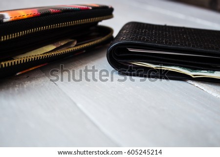 men's and women's wallet with money on wooden background