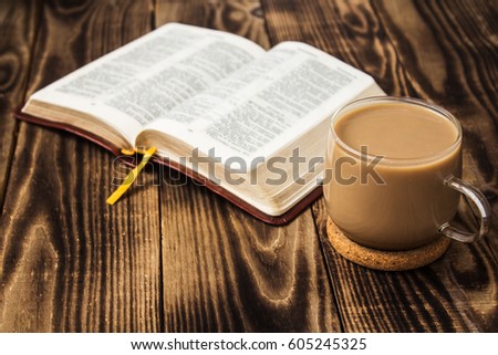 a bible and coffee with milk on wooden background Royalty-Free Stock Photo #605245325