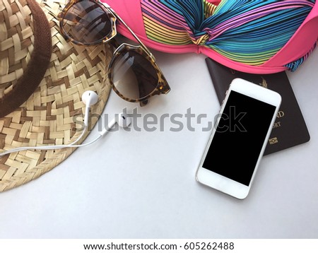 accessories for travel on white background, hat, sunglasses, bikini, smartphone, earphones and Thailand passport (Thai language on passport book is Thailand Passport), blurred