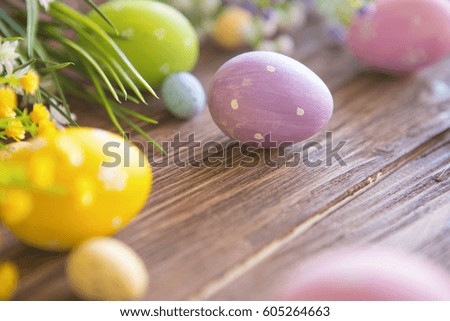 Easter eggs and spring flowers on an old wooden background.
