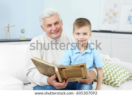 Grandfather looking at photo album with his grandchild
