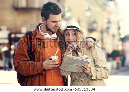 Couple tourist walking in downtown and eating ice cream.