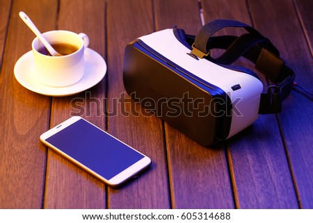 vr glasses and cell phone on wooden desk