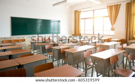 Empty classroom with chairs, desks and chalkboard. Royalty-Free Stock Photo #605319599