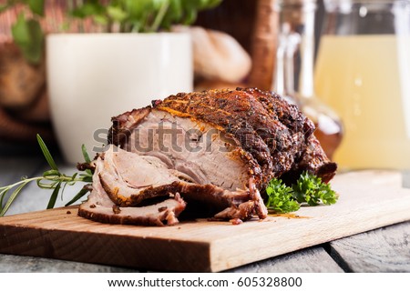 Roasted shoulder of pork on a cutting board Royalty-Free Stock Photo #605328800