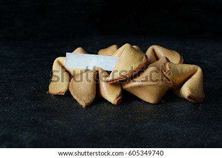 Fortune Cookies with blank paper on black background.