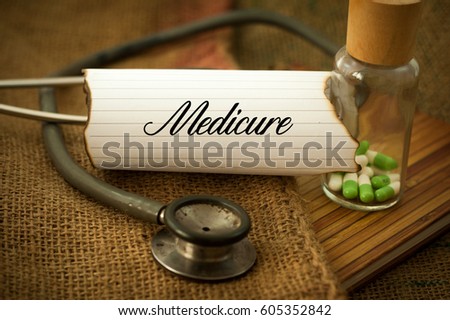 Medical concept, stethoscope and medicine over the sackcloth written MEDICURE.