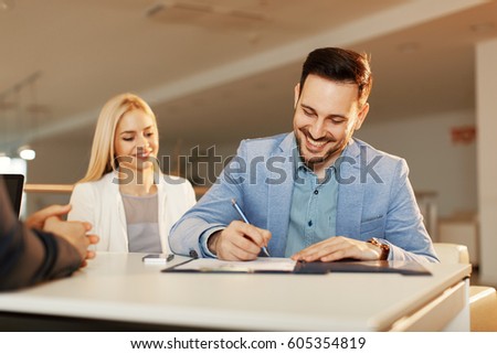 Young business couple signing a contract