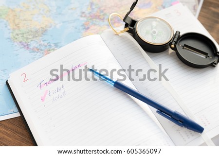 Planner To Do List for trip. Open daily, a compass, pen and a glasses on the desktop with maps. Travel concept