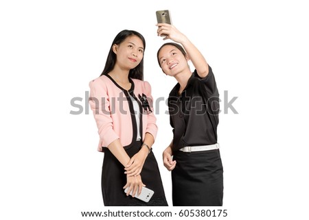 portrait of two beautiful asian business woman smiling and making a selfie with smart phone. Isolated on white background with copy space and clipping path