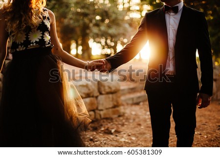couple holding hands silhouette. Fancy couple at sunset.