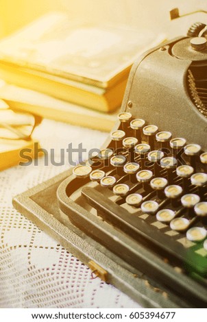 Vintage typewriter, old books on table