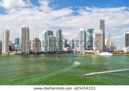 Aerial view of Miami skyscrapers with blue cloudy sky,white boat sailing next to Miami downtown
