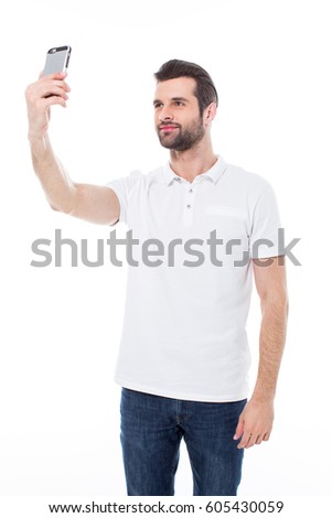 Handsome young man making selfie with smartphone isolated on white
