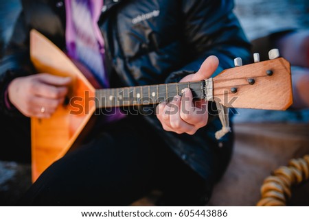 man is playing a balalaika, close-up