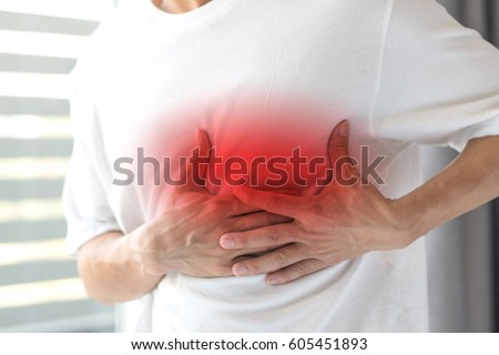 Man's hands on his chest in white shirt with red spot as suffering on chest pain. Male suffer from heart attack,Lung Problems,Myocarditis, heart burn,Pneumonia or lung abscess, pulmonary embolism day
 Royalty-Free Stock Photo #605451893