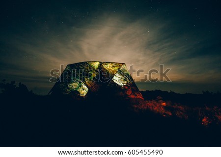 Tent camouflage against background of stars, dark toning