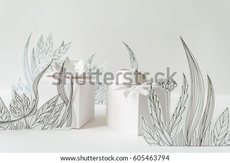 3d paper flowers with painted leaves and stems, white gifts and white paper flowers on the white background
