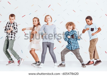 Group of boys and girls dancing at a party in a room