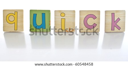 wooden tiles with the letters Q U I C K ( QUICK )