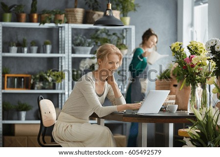 Two smiling florists working in a flower shop Royalty-Free Stock Photo #605492579