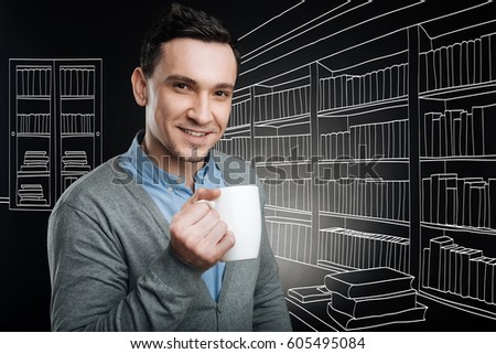 Positive handsome office worker drinking coffee