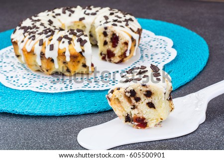 Homemade pastry-cake with chocolate and dried cherries, white icing