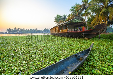 Beautiful sunset with houseboat in the backwaters of Kerala, India Royalty-Free Stock Photo #605506331