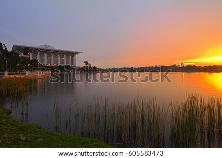 Glorious sunset view with reflection image on lake of Masid Besi, Putrajaya. Image has grain or blurry or noise and soft focus when view at full resolution. (Shallow DOF, slight motion blur)