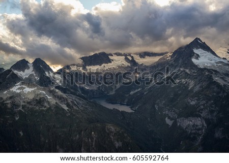 Aerial landscape view of Mount Tantalus and a Glacier Lake. Picture taken near Squamish, BC, Canada, during a cloudy sunset.