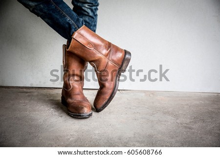 Legs of man wearing boots standing Royalty-Free Stock Photo #605608766