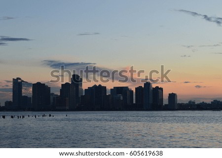 A view of New York City and the river in an orange sunset