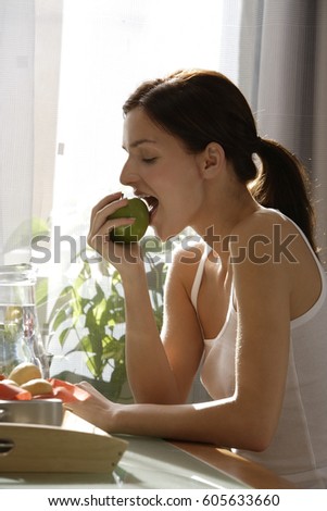 Profile of young woman eating apple