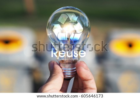 Reuse concept - Close up of hand holding light bulb with Recycle icon.