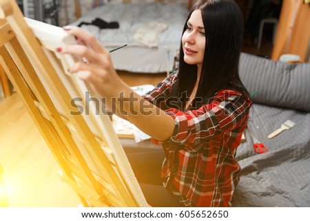 Beautiful long-haired brunette at easel