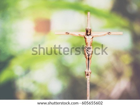 Brass crucifix of Jesus Christ with burred nature background, copy space