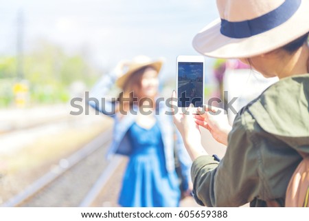 Traveler, Young backpacker taking a photo for her friend during waiting a train at train station for adventure trip - Journey concept