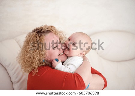 Young woman, mother, playing and laughs with a baby