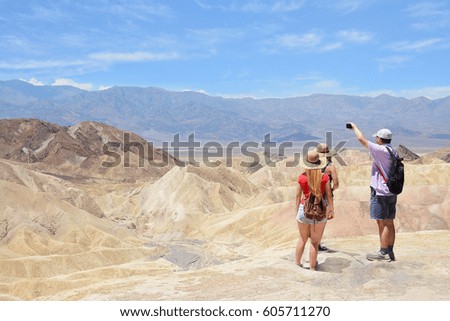 Family hiking in the mountains on vacation trip. father taking photos with his phone.Death Valley National Park landscape , eastern California and Nevada, USA.
