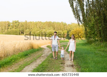 A young family with a small boy waiting for a second child. Future parents with a child outdoors in summer