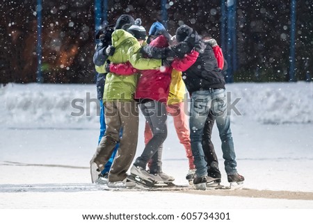 Group of young people embrace on a skating rink
