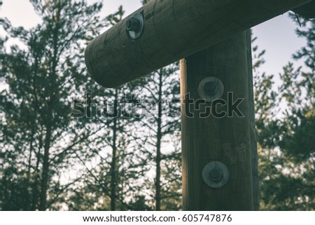 details of wooden watch tower deep in country forest with metal bolts - vintage green retro effect