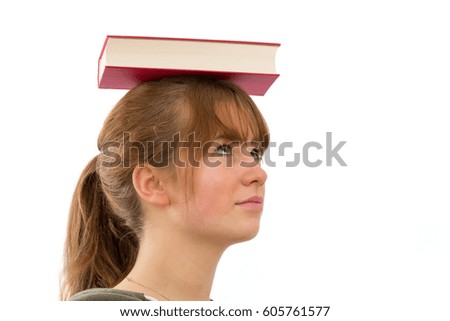 Attractive young woman balancing a book on her head. Isolated on white background.